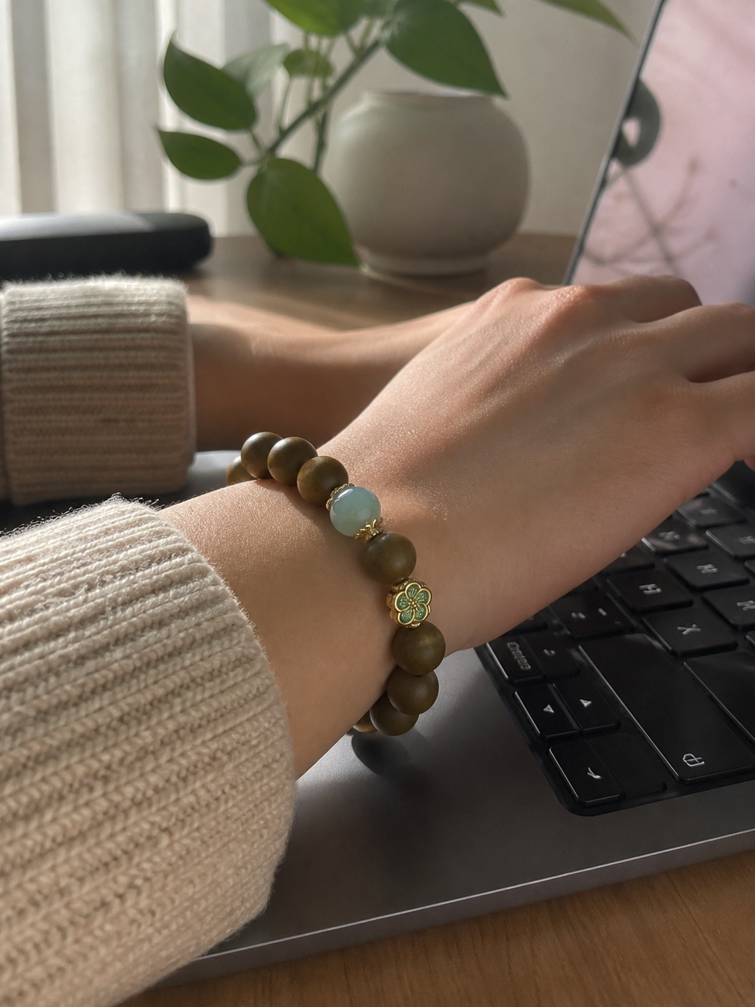 Customer wearing an olive incense bead bracelet while working