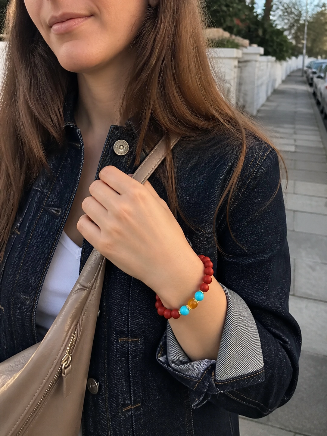 Western woman wearing a red incense bead bracelet outdoors