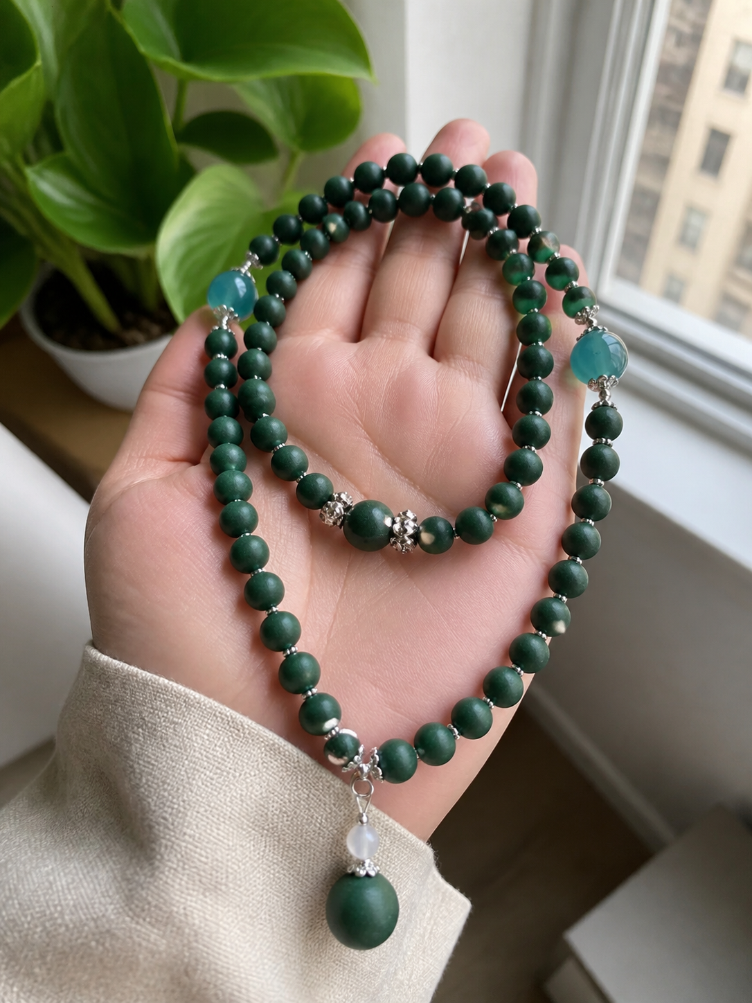 Customer holding a green double-loop incense bead strand